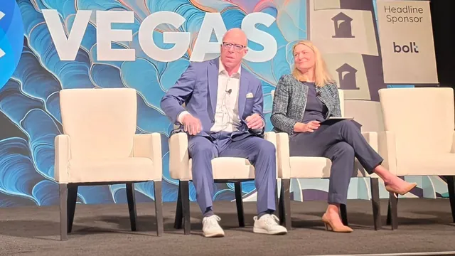 Two panelists seated on white chairs on the ITC Vegas stage, with the lighthouse backdrop and bolt headline sponsor signage behind them.